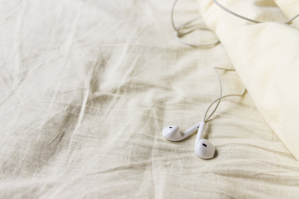 耳机在皱巴巴的床上图片下载