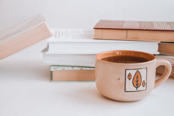 旧书教育理念背景的堆叠，许多书籍堆放为文本复制空间，书顶与一杯热茶图片下载