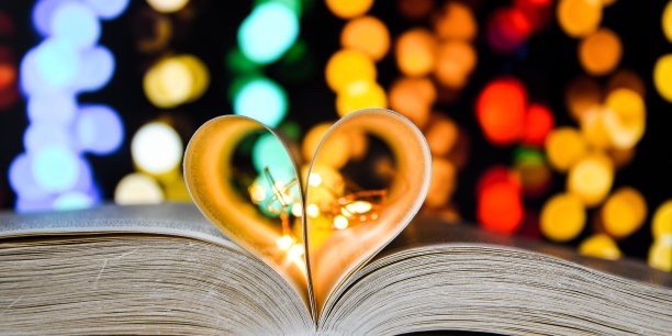 书与爱的象征孤立在散景的背景，心形的特写图片下载