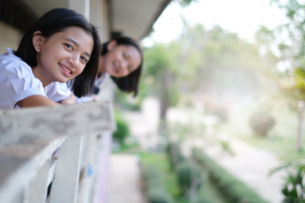 快乐年轻的亚洲女孩穿校服在学校。图片下载