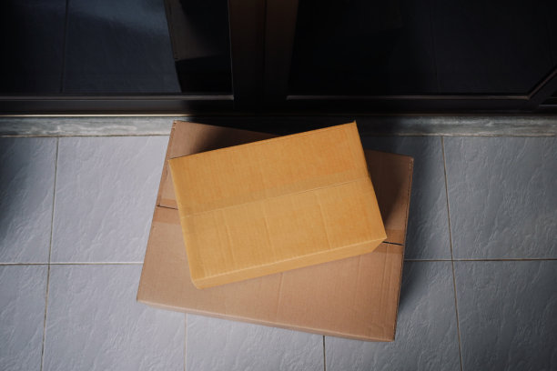 2019冠状病毒(COVID-19)大流行期间，非接触式安全快递服务送货上门，在家门口门廊上俯瞰投递的纸箱包裹。图片下载