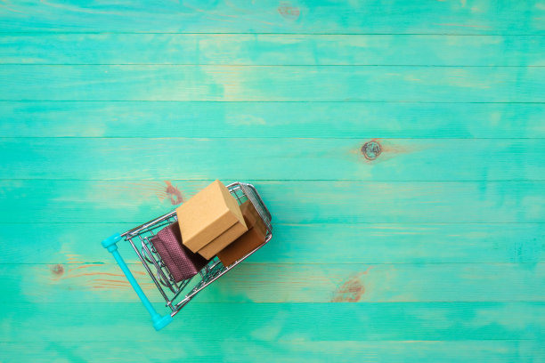 一个购物车与箱子在木制背景图片下载