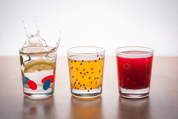 鸡尾酒和饮料。一杯装着饮料的玻璃杯里掉了一个柠檬。运动被冻结。图片下载