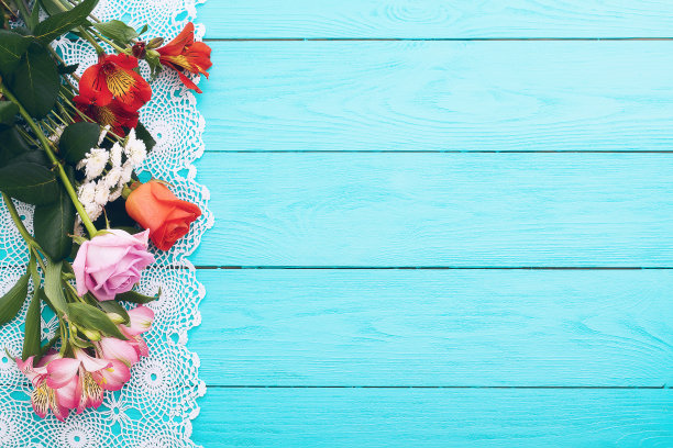 卡片上的花和花边桌布上的蓝色木制背景。俯视图和选择焦点。本空间图片下载