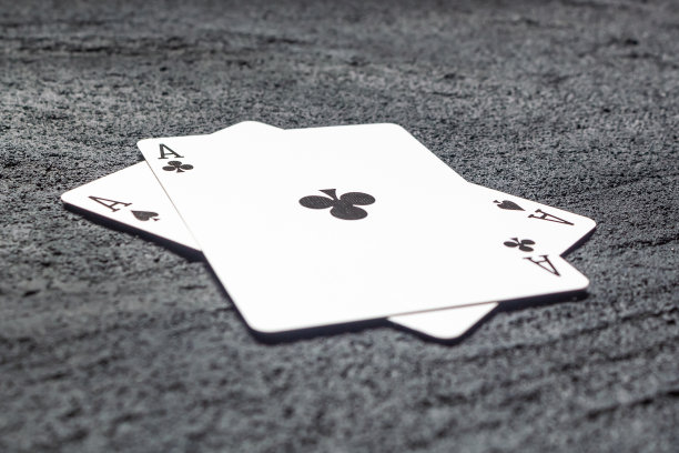 两个黑色的ACES铁锹和十字架在黑色混凝土黑色背景。复制空间图片下载