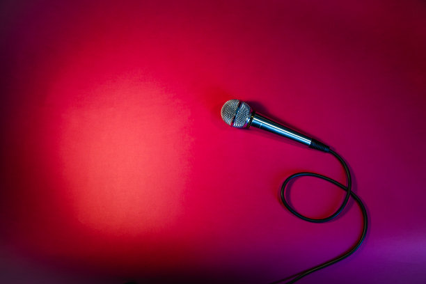 红色背景上的银色麦克风。图片下载