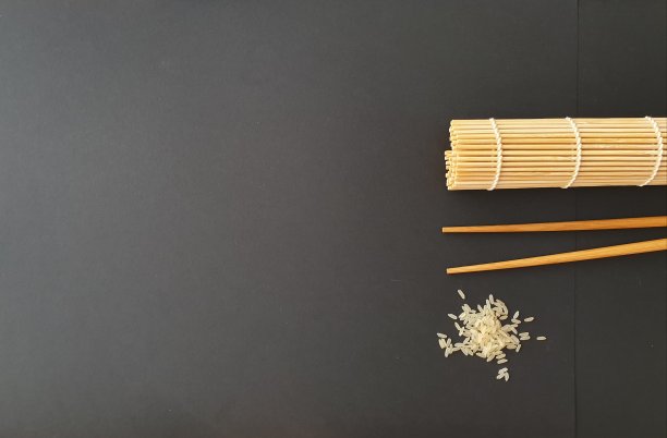 俯视图卷寿司席，与筷子和米饭。的背景图片。寿司概念，日本料理，中国料理，亚洲料理。有用的模板配方准备，餐厅菜单。副本的空间。图片下载
