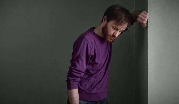 一个躲在角落里的抑郁的年轻人图片下载