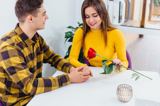 小伙子送花给他的女朋友，握着她的手，肯定是要求婚。图片下载