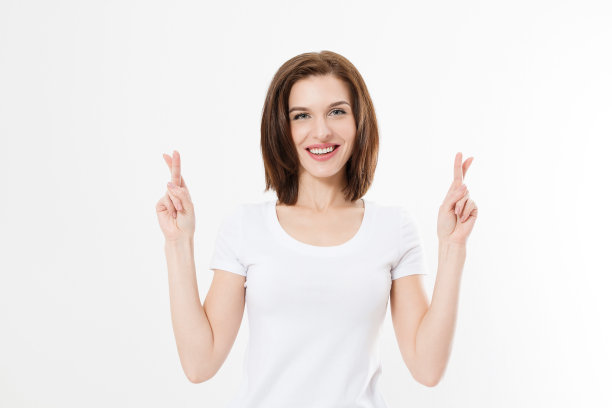 年轻女子交叉手指希望好运孤立在白色背景。模板夏季t恤。本空间图片下载