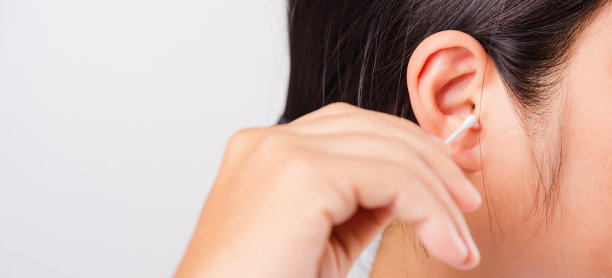 亚洲美丽的女人清洁耳朵hrt使用棉签在白色背景与文本副本规格，保健概念图片下载