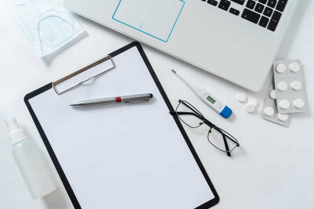 俯视图医生的工作场所。桌子上有玻璃杯、温度计和药品图片下载