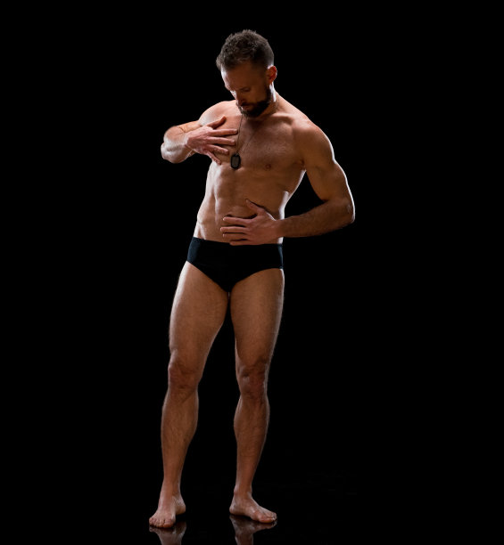白人中年人穿着内衣站在黑色背景前图片下载