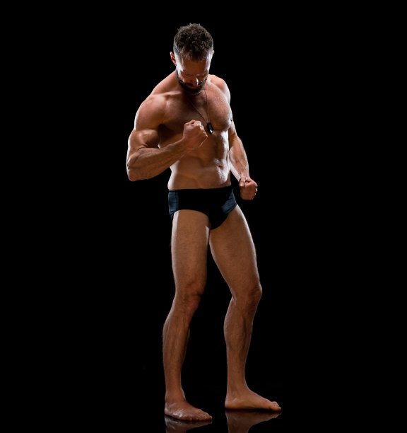 白人中年人穿着内衣站在黑色背景前图片下载