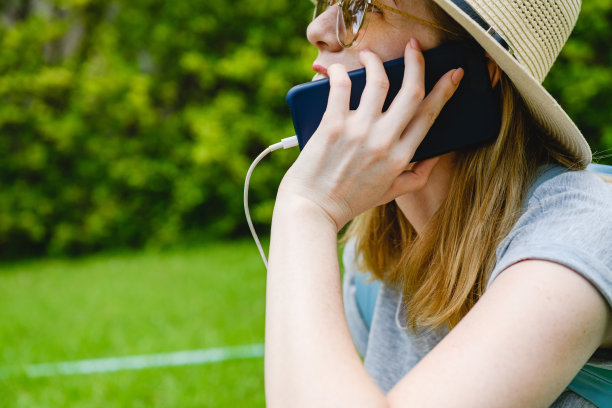 女人在户外充电时用智能手机说话图片下载