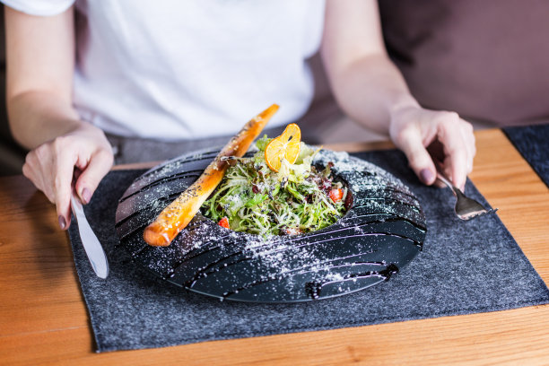 一个女人正在吃健康的午餐。帕玛森奶酪沙拉图片下载