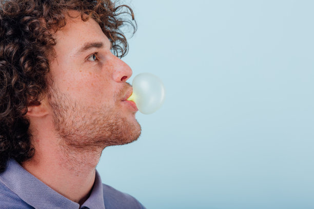 穿着衬衫吹泡泡糖的胡子拉碴男人图片下载