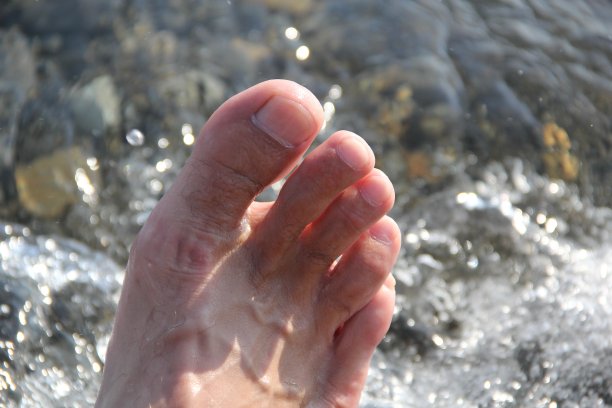 男人的腿在海滩上对着大海图片下载