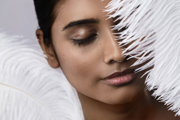 拿着柔软鸵鸟毛的年轻性感印度女人图片下载