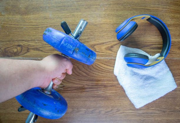 男人拿着哑铃旁边的毛巾和耳机在健身组成，pov图片下载