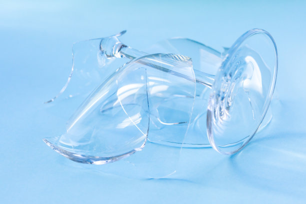 破碎的酒杯在白色背景上的特写概念设计。破碎的玻璃材质。图片下载