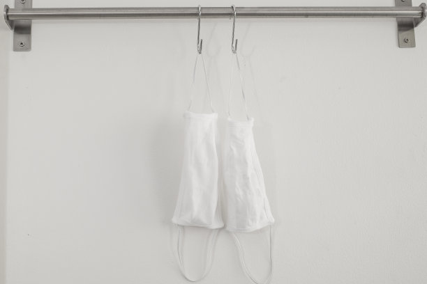在衣钩上挂两个棉布口罩或卫生口罩。预防covid-19病毒感染，图片下载