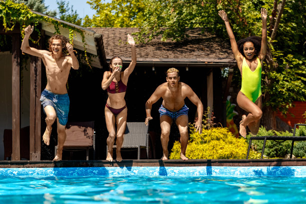 暑假。年轻人兴奋地笑着跳进泳池图片下载