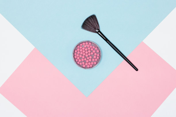 用扇形化妆刷刷粉球。俯视图，平放图片下载