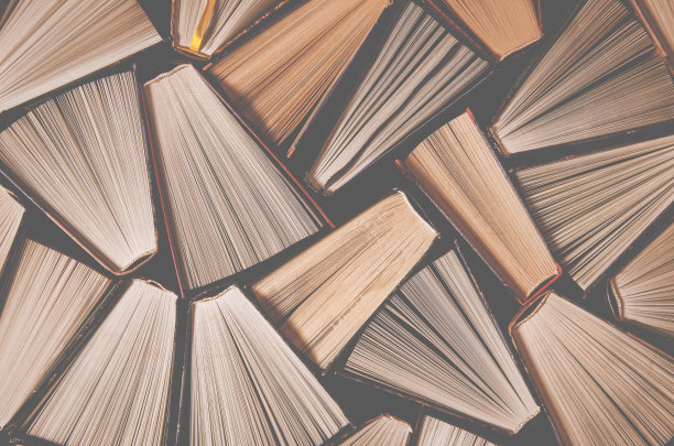 图书馆的书架上放着许多翻开的五颜六色的旧书图片下载