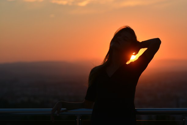 夕阳下凌乱的年轻女子剪影图片下载