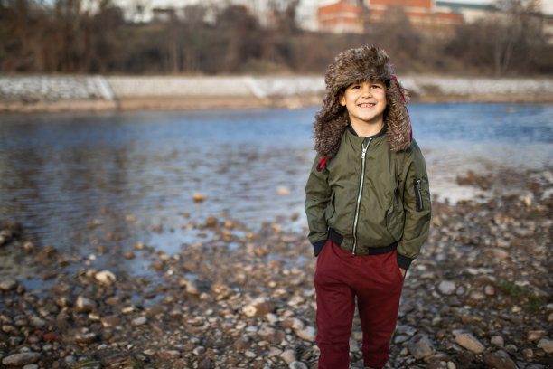 一个可爱的男孩在河岸上散步图片下载