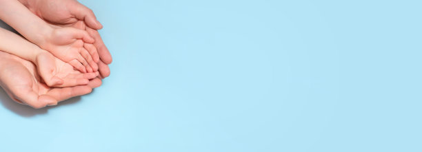 大人的手握着孩子的手。横幅。文本复制空间。图片下载