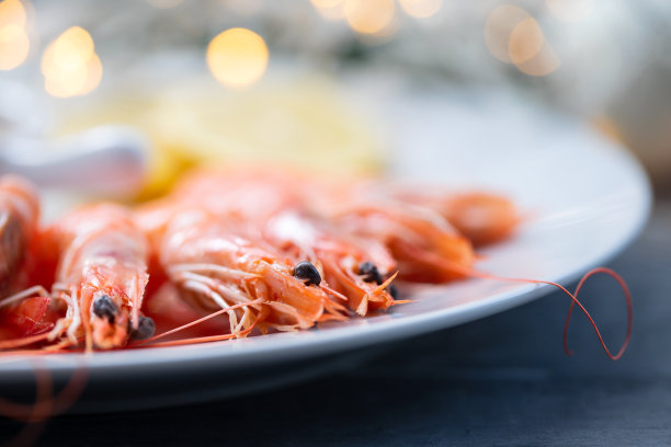 在陶瓷背景上的白盘子上煮虾图片下载