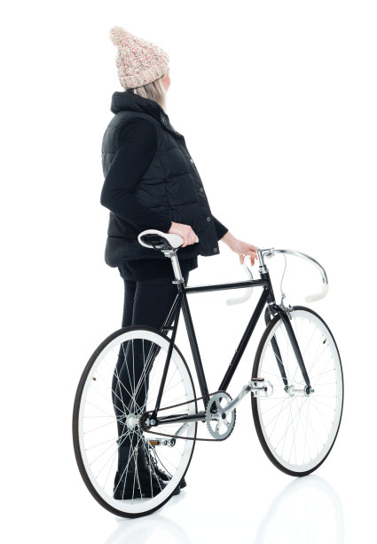 白人女性无袖站在白色背景前，穿着靴子，骑着自行车图片下载