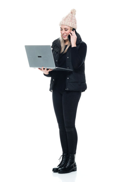 白人女性无袖站在白色背景下穿着毛衣使用笔记本电脑图片下载