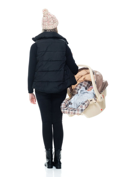 白种人婴儿-人类年龄无袖站在白色背景前，穿着裤子和抱着汽车安全座椅图片下载