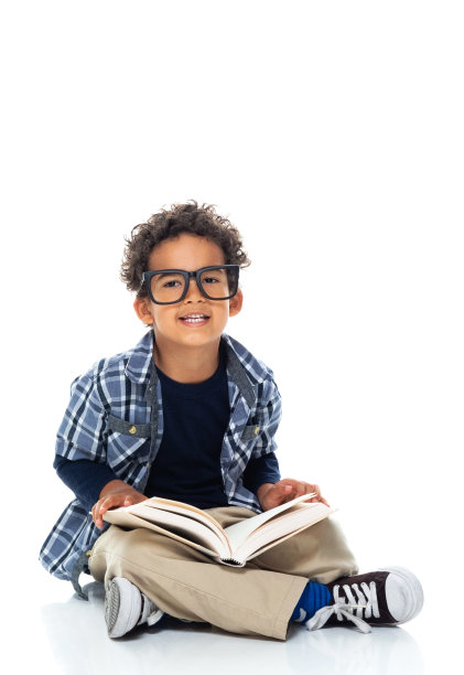 男生同学坐在白色背景前，戴着眼镜，拿着课本图片下载