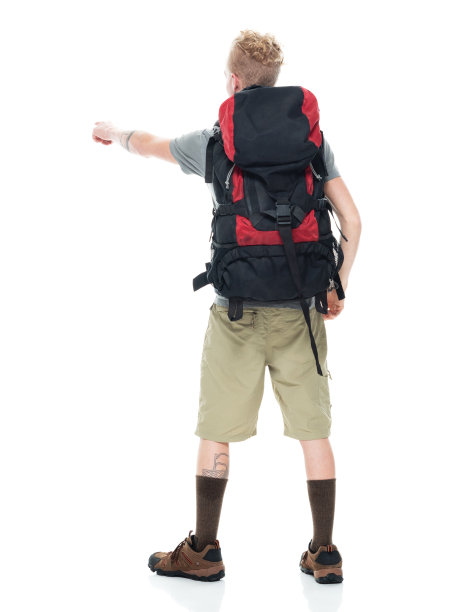 白人年轻男性背包客徒步旅行在前面的白色背景穿着徒步靴和拿着包图片下载