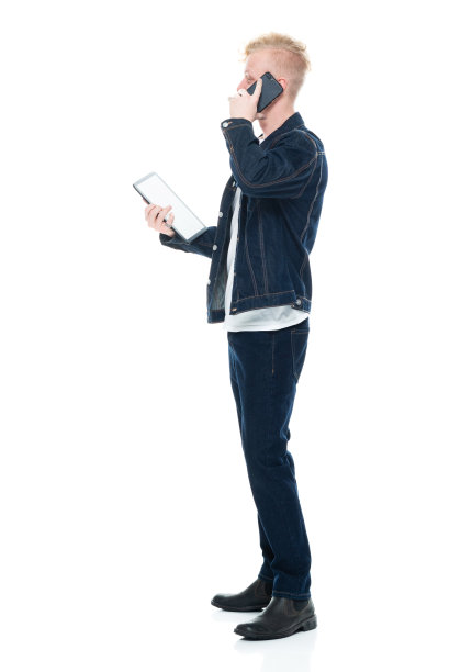 白人男性穿着靴子，用触摸屏站在白色背景前图片下载