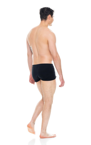 白人年轻男性穿着平角短裤走在白色背景前图片下载