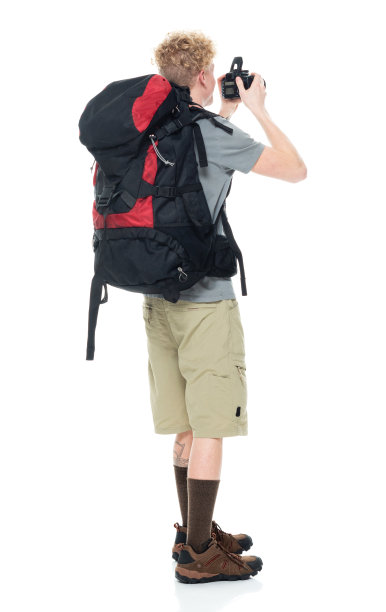 白人年轻男性摄影师徒步在白色背景穿着t恤和拿着相机图片下载