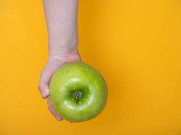 一个小孩手里拿着一个绿苹果图片下载