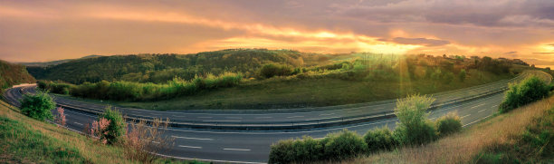 在美丽的日落下，空旷的公路上坡。图片下载