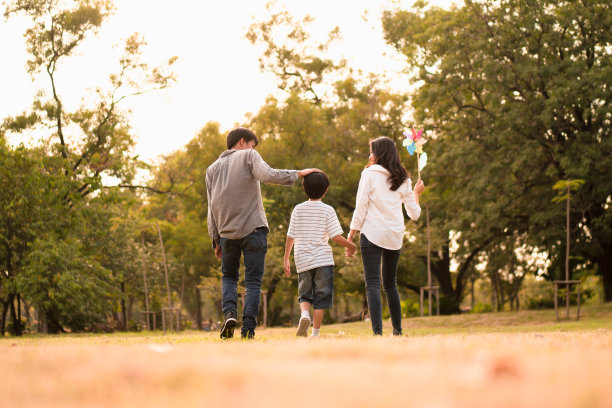 从背后的亚洲幸福家庭花时间在公园散步和放松在秋天的下午，概念家庭团聚，温暖的家庭，为人父母，快乐的家庭郊游。图片下载
