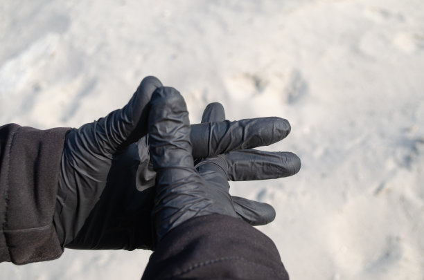 双手戴着黑色乳胶手套。图片下载