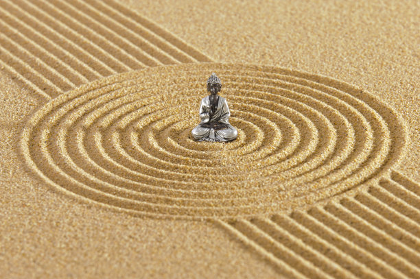 日本禅宗花园，石头在纹理的沙子和佛像雕塑图片下载