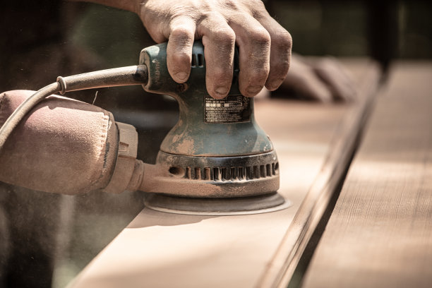 用轨道砂光机在户外打磨红木木板图片下载