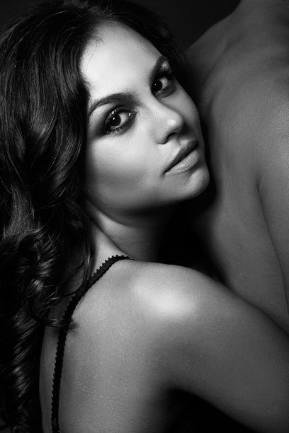 一个美丽的女人和一个赤裸到腰部的男人在她身后图片下载