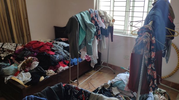 一个十几岁女孩的卧室里乱七八糟的，包括衣服和包图片下载