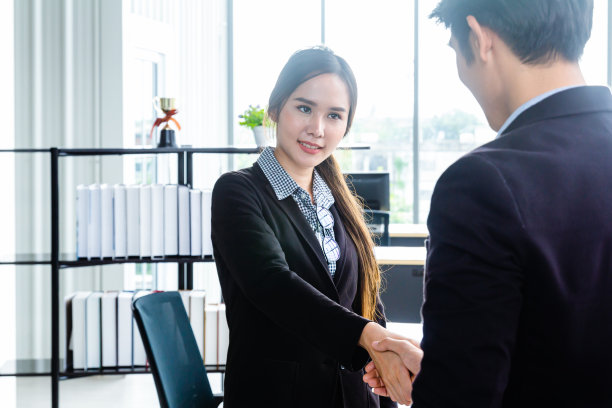 年轻的亚洲商人站在现代办公室里谈论金融业务概念，就贸易提议达成一致图片下载